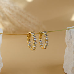 Thea eternity hoop earrings in 18K gold plate, medium hoops set with round white cubic zirconia, hanging on a gold wire