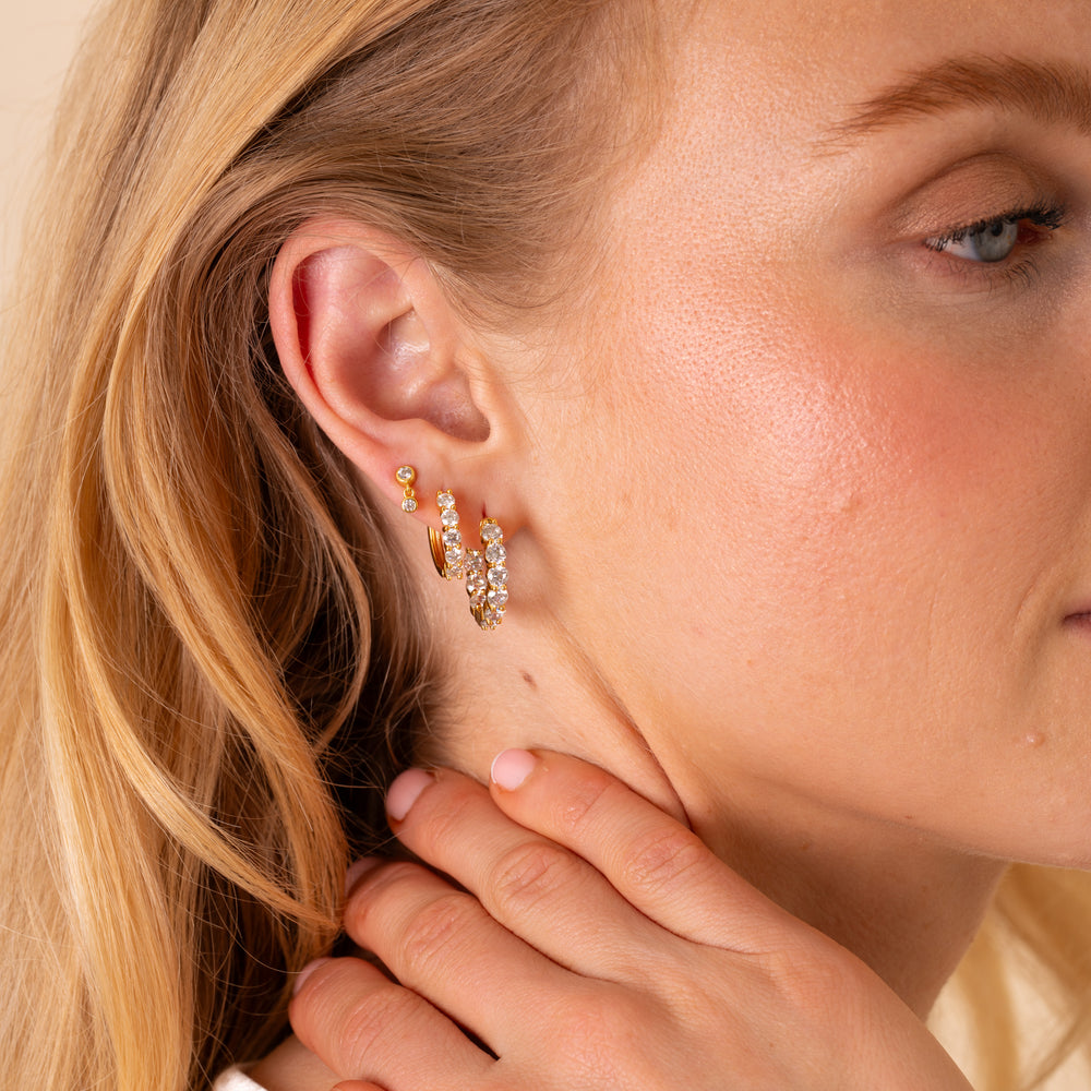 Thea eternity hoop earrings in 18K gold plate, medium hoops set with round white cubic zirconia, hanging on a gold wire