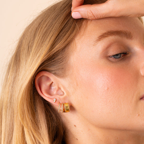 Model wearing the Maia double-row huggie with the Stella stud and Luna wide huggie in one ear - Rainbow Rocks