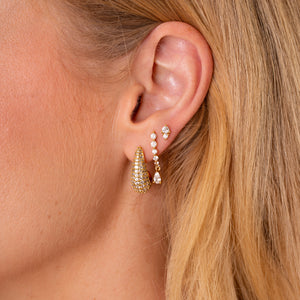 Ear styled with the Lyra curved CZ drop earring and dainty gold stud earrings - Rainbow Rocks
