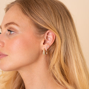 Model wearing an ear stack of the Adara pave teardrop hoop, Lyra curved drop and Stella two-stone stud, 18K gold plated - Rainbow Rocks